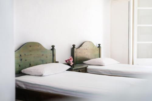 two beds in a room with white walls at Corfu 9 Muses Ipsos in Ipsos