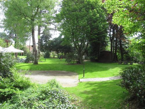 a park with green grass and trees and a path at Hotel Zur Heide in Aachen