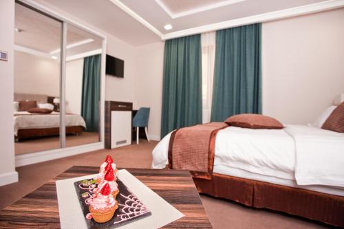 a hotel room with a bed and a table with cupcakes at Wellness & Spa Hotel ACD in Herceg-Novi