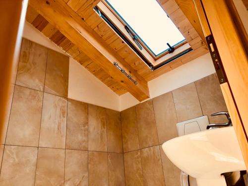 a bathroom with a sink and a skylight at Bujtina Polia in Theth