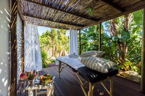 a porch with a bed and a table at Ocean Lounge in Cape Town