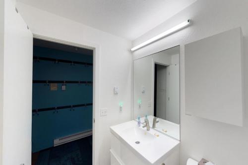 ein Badezimmer mit einem weißen Waschbecken und einem Spiegel in der Unterkunft Brighton #116 in Girdwood