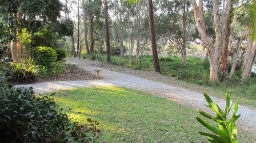 a gravel path in a park with a bench on it at Lake Russell Lakeside Retreat in Emerald Beach