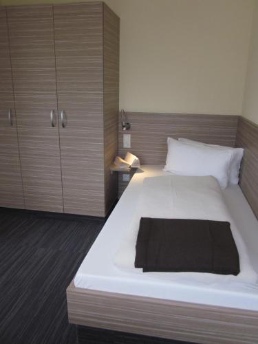 a bedroom with a large bed with a black blanket on it at Hotel Zur Heide in Aachen
