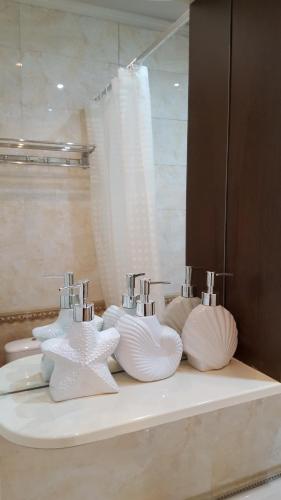 a bathroom counter with three sinks and two faucets at Apartment on Nazarbayeva 77 in Almaty