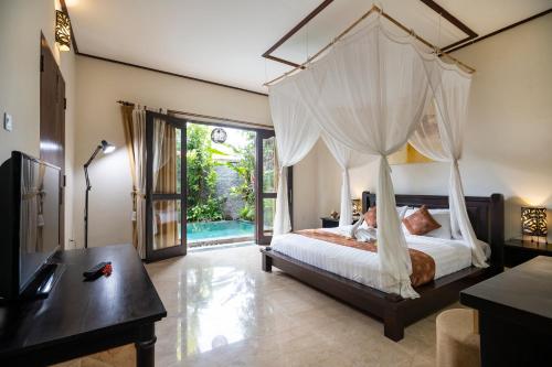a bedroom with a canopy bed and a pool at Bali Ayu Hotel & Villas in Seminyak