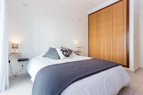 um quarto com uma cama grande e um armário de madeira em Kali Apartment - with Pool em Portimão