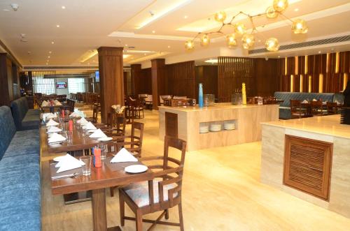 a restaurant with wooden tables and chairs and a bar at Radisson Chandigarh Zirakpur in Chandīgarh