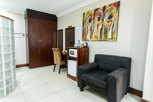 a living room with a chair and a table at Royl Court Guesthouse in Kimberley