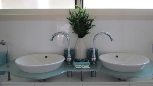 two sinks in a bathroom with two faucets at Lake Russell Lakeside Retreat in Emerald Beach
