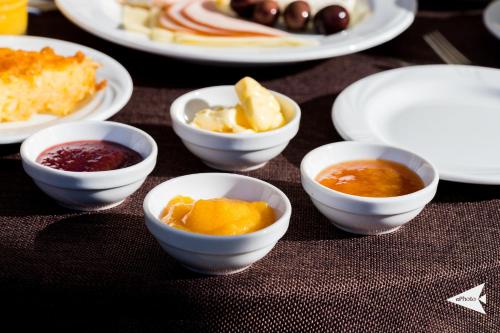 a table topped with white bowls of food on plates at Villa Paroraia in Tsepelovo
