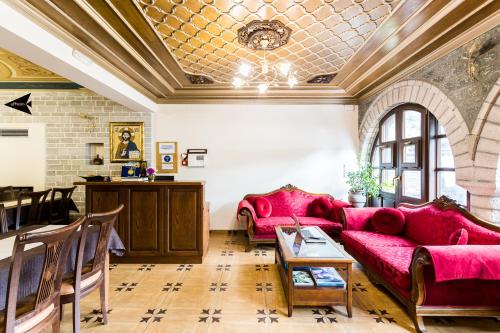 a living room with red couches and a table at Villa Paroraia in Tsepelovo