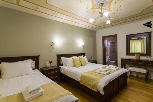 a bedroom with two beds and a chandelier at Villa Paroraia in Tsepelovo