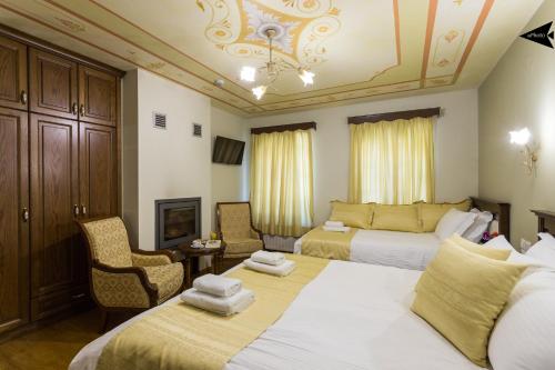 a hotel room with two beds and a chair at Villa Paroraia in Tsepelovo