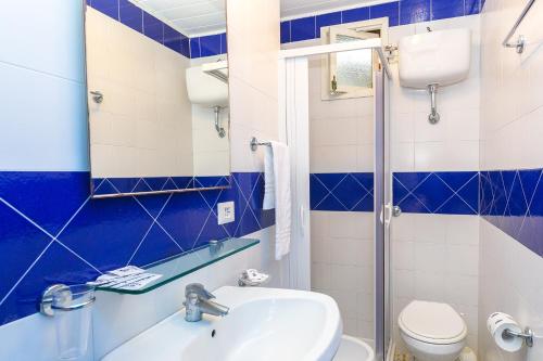 a blue and white bathroom with a sink and a toilet at Bleu Village in Meta