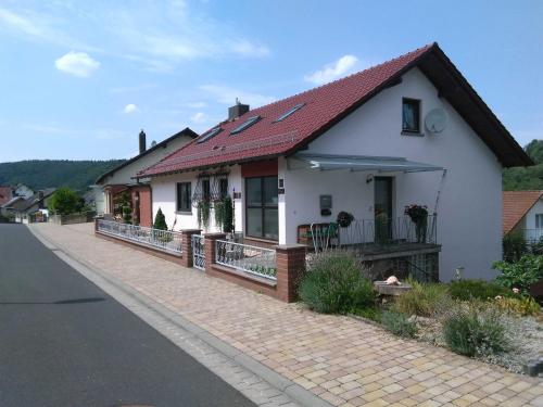 uma casa branca com um telhado vermelho numa rua em Gästehaus Natterer - FeWo 2 em Momlingen