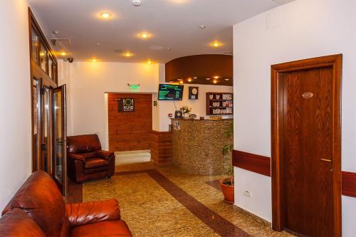 a lobby with a leather couch and a bar at Hotel Piatra Soimului in Sinaia