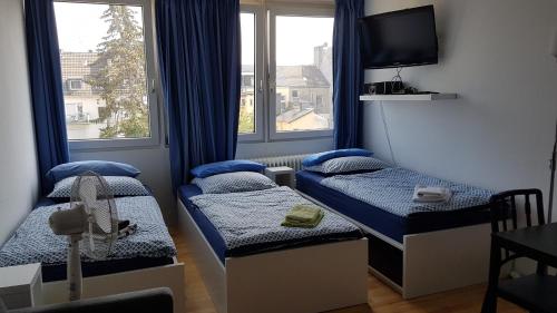 una piccola stanza con due letti e una finestra di Sonniges Modernes Appartement Höhenberg a Colonia