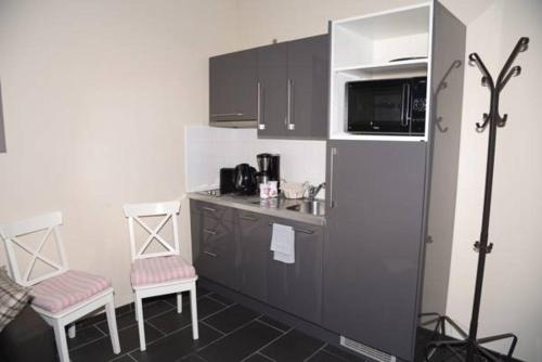 a small kitchen with two chairs and a microwave at Appartbrussels in Brussels