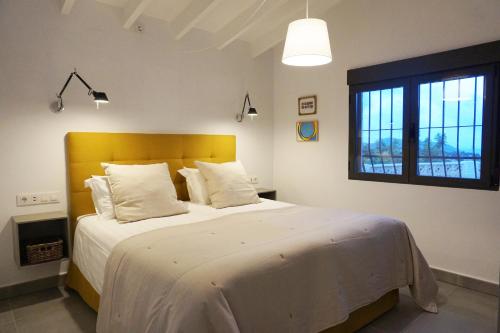 テウラーダにあるCasa Nidoのベッドルーム(黄色のヘッドボード付きの大きな白いベッド1台付)