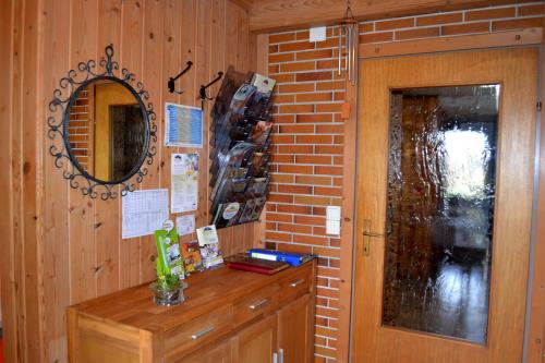 eine Backsteinwand mit einem Spiegel und einer Holztür in der Unterkunft Gästehaus Pfisterer in Bad Schallerbach