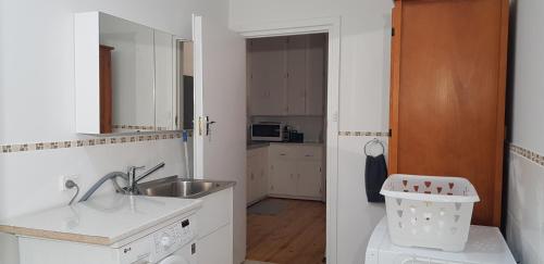 a small white kitchen with a sink and a sink at Unit in Marion in Sturt