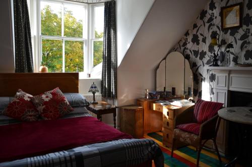 a bedroom with a bed, a chair, and a window at Averon House in Inverness