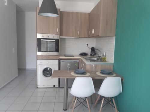 una cucina con tavolo e alcuni elettrodomestici bianchi di Cozy Apartment a Heraklion