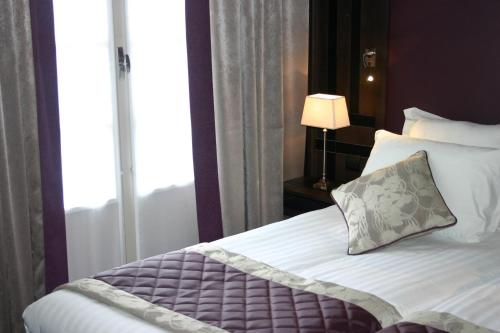 a bedroom with a bed with a pillow and a window at Hotel Bellevue in Amboise