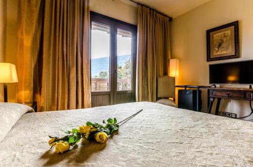 a hotel room with a bed with flowers on it at Hotel Temple Ponferrada in Ponferrada