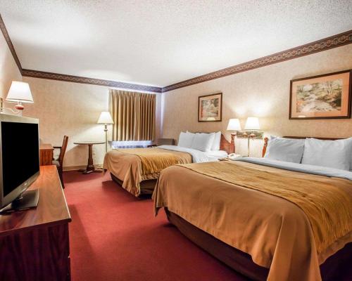 a hotel room with two beds and a flat screen tv at Quality Inn Midway in Bethel