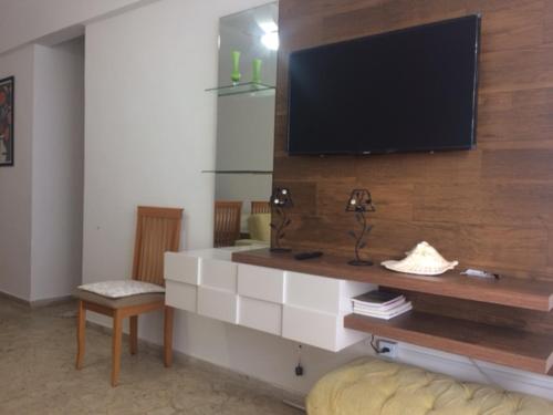 a living room with a flat screen tv on a wall at Praia Grande Frente ao Mar-Albatroz in Praia Grande