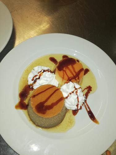 a dessert on a white plate with ice cream and sauce at Hotel Reina Isabel in Lleida