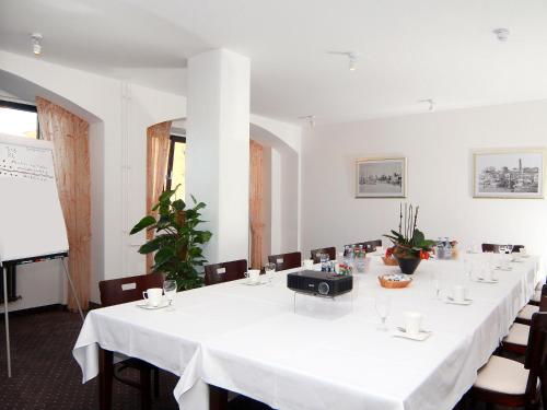 a meeting room with a long table with chairs and a projector at Elbe Resort Alte Ölmühle in Wittenberge