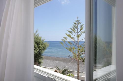 a window with a view of the ocean at Sigalas Beach Hotel in Kamari