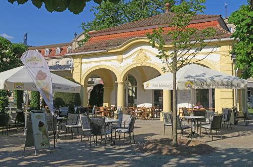 a group of tables and chairs in front of a building at Villa Widder - Boutiquehotel in Staatsbad Brückenau