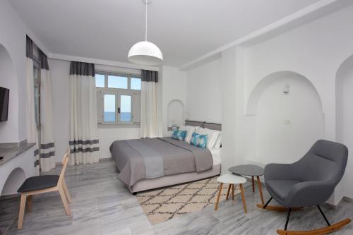 a bedroom with a bed and a desk and a chair at Sigalas Beach Hotel in Kamari