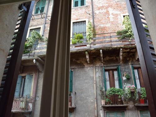 a window view of an old building with potted plants at Albergo Mazzanti in Verona