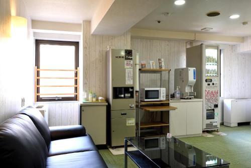 a living room with a couch and a kitchen at Hotel Johzenji in Sendai