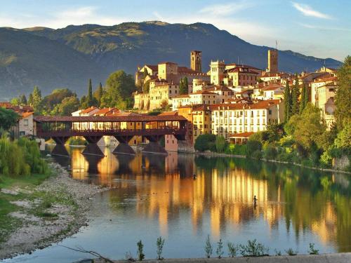 a city with a bridge over a river with buildings at Su Misura in Molini