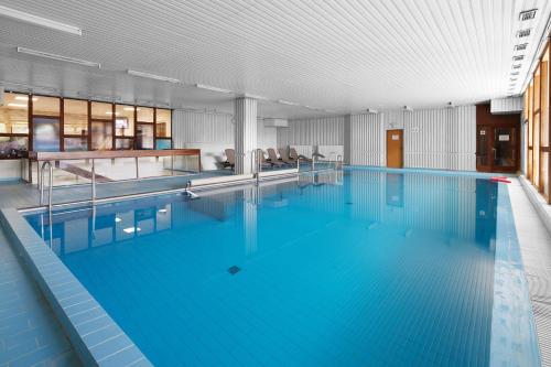 a large swimming pool with blue water in a building at Hotel Červenohorské sedlo in Loučná nad Desnou