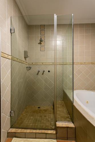 a shower with a glass door in a bathroom at Royl Court Guesthouse in Kimberley
