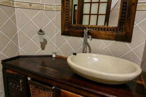 a bathroom with a sink and a mirror on a counter at Royl Court Guesthouse in Kimberley
