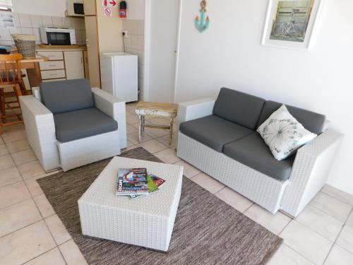 ein Wohnzimmer mit 2 Stühlen, einem Sofa und einem Tisch in der Unterkunft Rivertides Self Catering Guest House in Velddrif
