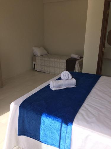 a room with a bed with towels on it at Pousada Vila Regina in Penha