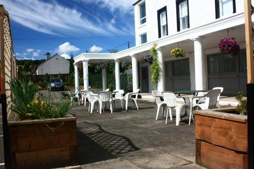 a group of white chairs and tables on a patio at Annandale Arms Hotel in Moffat