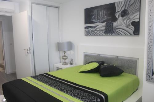 una camera con un letto verde e un dipinto sul muro di Happy House a Ponta Delgada