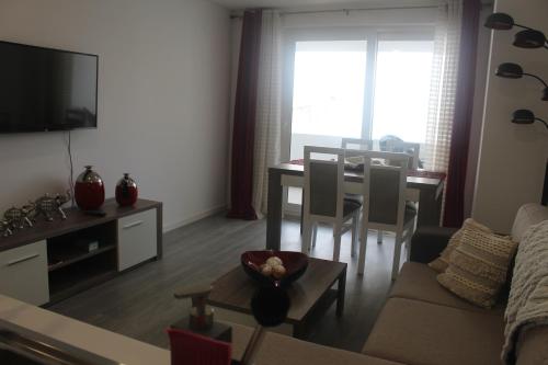 a living room with a couch and a dining room table at Happy House in Ponta Delgada