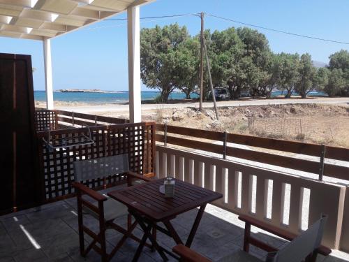 a table and chairs on a porch with a view of the beach at Kolimbito Sea Side in Falasarna