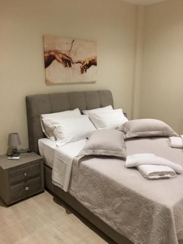 a bedroom with a bed and a painting on the wall at Acropolis brand new 1min from metro! in Athens